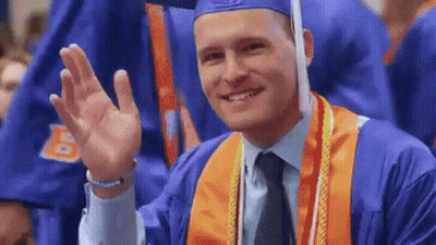 A Man In A Graduation Cap And Gown Waving His Hand GIF