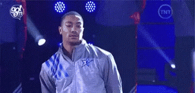 A Man In A Gray Jacket Is Standing On A Stage In Front Of A Blue Background . GIF