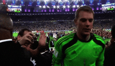 A Man In A Green Adidas Jersey Stands In Front Of A Crowd Of People GIF