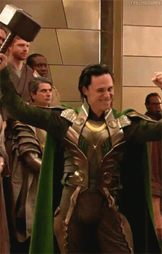 A Man In A Green Cape Is Holding A Hammer In Front Of A Group Of People With The Caption Feelingshare GIF
