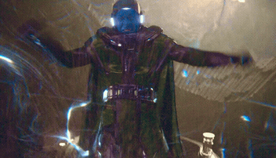 A Man In A Green Cape Is Standing In A Dark Room GIF