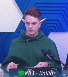 A Man In A Green Cape With Elf Ears Is Standing In Front Of A Podium With The Name Will Written On It GIF