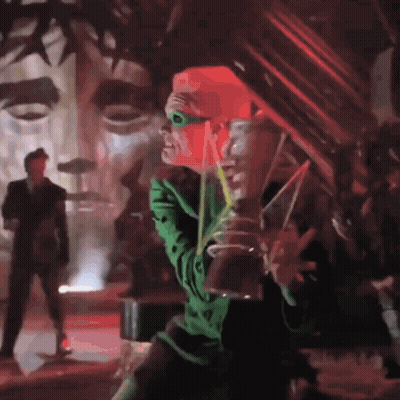 A Man In A Green Costume Is Drinking From A Glass GIF