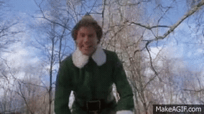 A Man In A Green Elf Costume Is Standing In The Woods . GIF