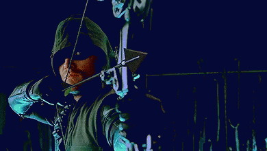 A Man In A Green Hooded Jacket Is Holding A Bow And Arrow In His Hand . GIF