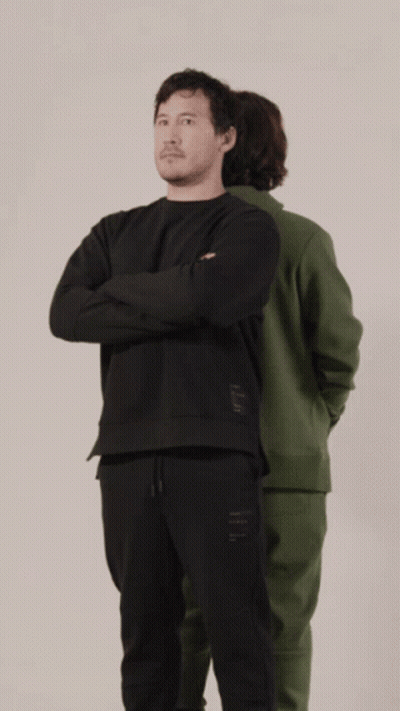 A Man In A Green Hoodie And A Man In A Black Hoodie Are Standing Back To Back GIF