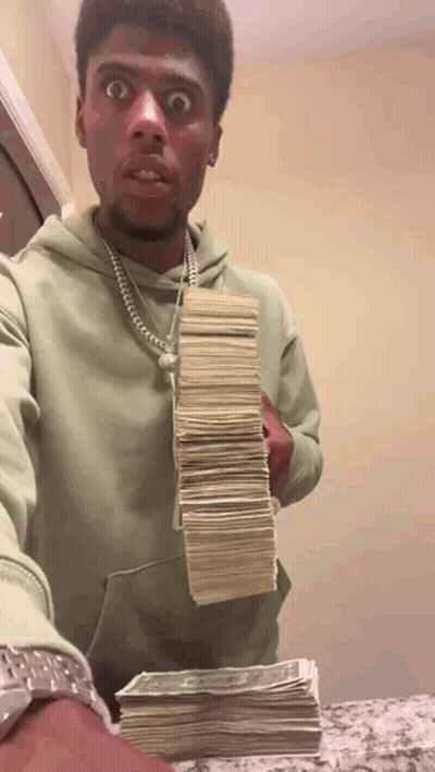 A Man In A Green Hoodie Is Holding A Stack Of Money .. GIF