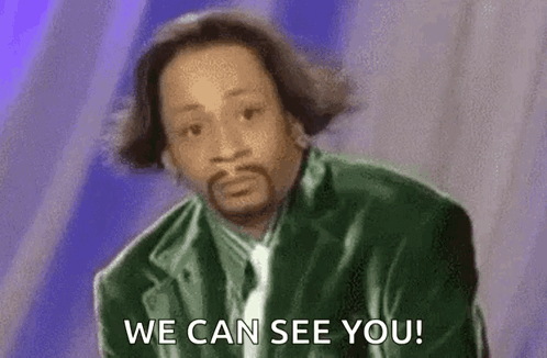 A Man In A Green Jacket And Tie Is Saying `` We Can See You '' . GIF