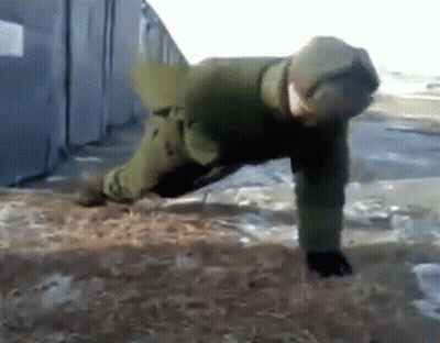 A Man In A Green Jacket Is Doing Push Ups In The Dirt GIF