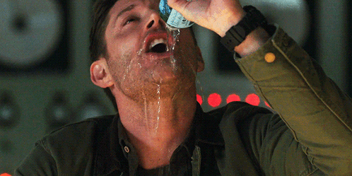 A Man In A Green Jacket Is Drinking From A Can Of Soda GIF