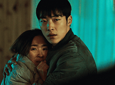 A Man In A Green Jacket Is Hugging A Woman In A White Coat GIF