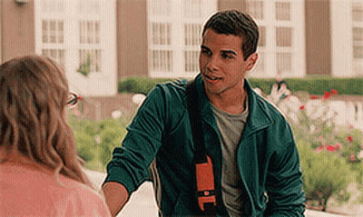 A Man In A Green Jacket Is Shaking A Woman 'S Hand . GIF