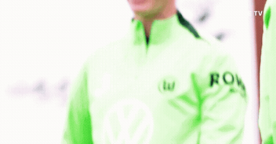 A Man In A Green Jacket Is Smiling And Holding His Arms Up . GIF