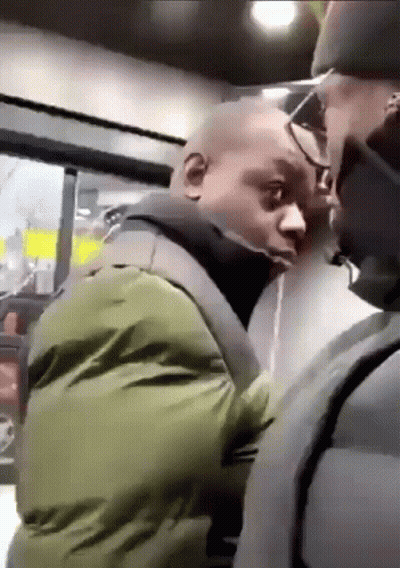 A Man In A Green Jacket Is Standing Next To Another Man In A Black Jacket . GIF