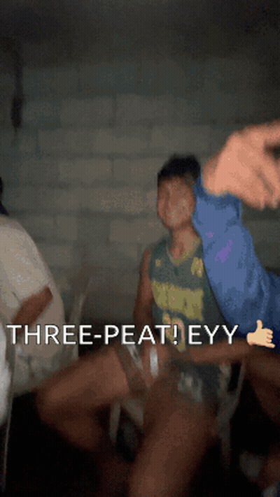 A Man In A Green Jersey Says " Three-Peat Eyy " In A Dark Room GIF