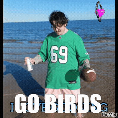 A Man In A Green Jersey With The Number 69 Is Holding A Football GIF