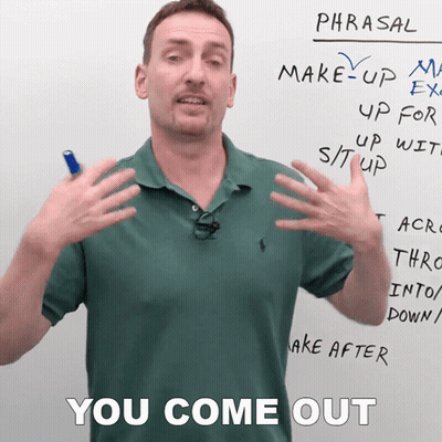A Man In A Green Polo Shirt Stands In Front Of A Whiteboard That Says Phrasal GIF
