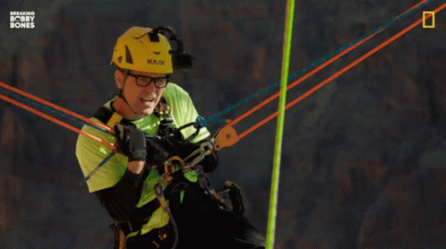 A Man In A Green Shirt And A Yellow Helmet Says " I 'M Just Holdin ' On, Man " GIF
