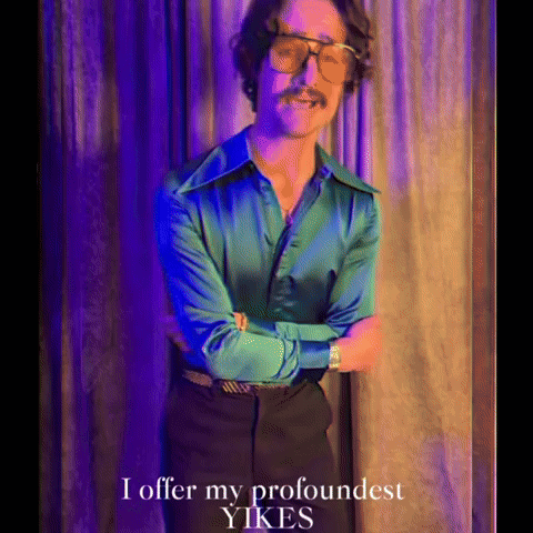 A Man In A Green Shirt And Black Pants Is Standing With His Arms Crossed And The Words I Offer My Profoundest Yikes GIF