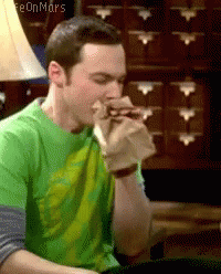 A Man In A Green Shirt Eating A Sandwich GIF