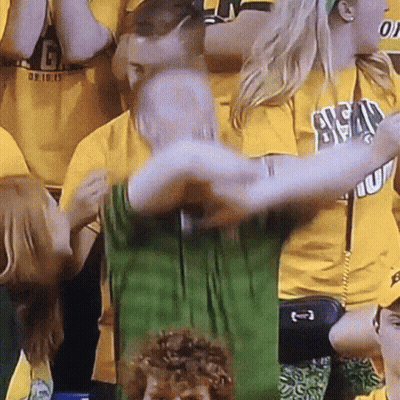 A Man In A Green Shirt Is Being Hugged By A Woman In A Yellow Shirt That Says Ucsd GIF