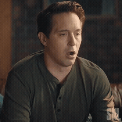 A Man In A Green Shirt Is Blowing A Bubble With A Snl Logo In The Corner GIF