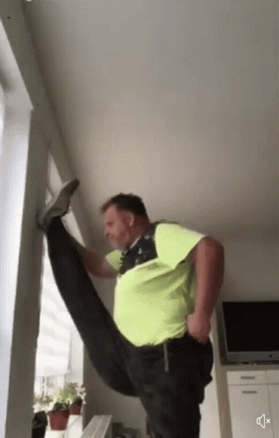 A Man In A Green Shirt Is Doing A Split GIF