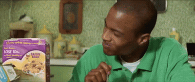 A Man In A Green Shirt Is Eating Raisin Bran GIF