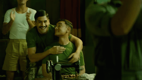 A Man In A Green Shirt Is Hugging Another Man In A White Shirt GIF