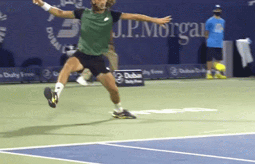 A Man In A Green Shirt Is Jumping In The Air On A Tennis Court With J.p. Morgan In The Background GIF
