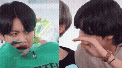 A Man In A Green Shirt Is Making A Funny Face And A Man In A Black Shirt Is Covering His Nose . GIF