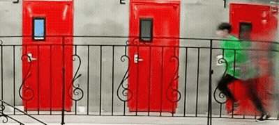 A Man In A Green Shirt Is Running Across A Balcony With Red Doors In The Background . GIF