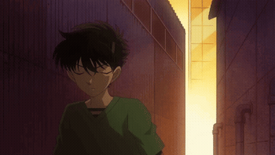 A Man In A Green Shirt Is Standing In A Dark Alleyway GIF