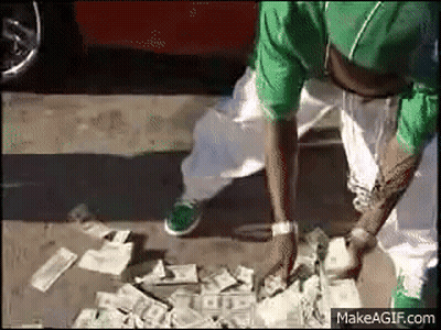 A Man In A Green Shirt Is Standing Next To A Pile Of Money On The Ground . GIF