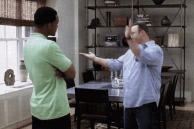 A Man In A Green Shirt Is Standing Next To Another Man In A Blue Shirt GIF