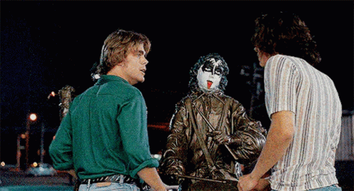 A Man In A Green Shirt Is Standing Next To Two Other Men GIF