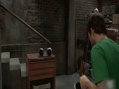 A Man In A Green Shirt Stands In Front Of A Sign That Says " Fly Eagles Fly " GIF