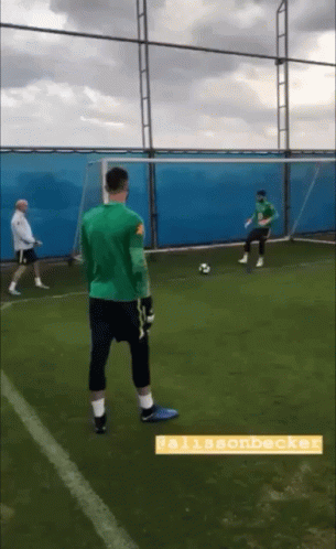 A Man In A Green Shirt Stands On A Soccer Field With The Name Allisonbeck On The Bottom GIF