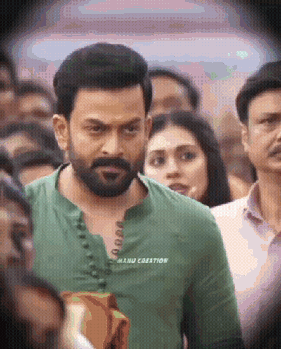 A Man In A Green Shirt With Manu Creation Written On The Front GIF
