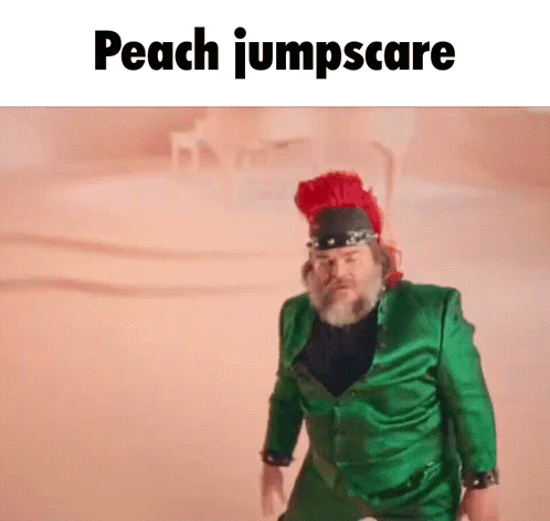 A Man In A Green Suit And A Red Hat Is Standing In The Sand . GIF