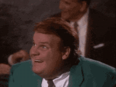 A Man In A Green Suit And Tie Is Smiling While Looking Up . GIF