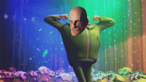 A Man In A Green Suit Is Flexing His Muscles In Front Of Minions GIF