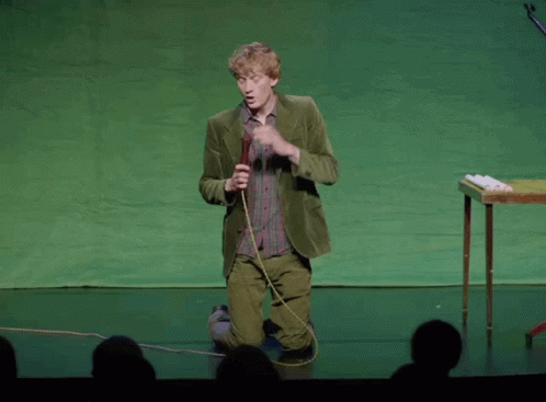 A Man In A Green Suit Is Kneeling Down And Holding A Microphone With The Words By Something I 100 Percent Agree With GIF
