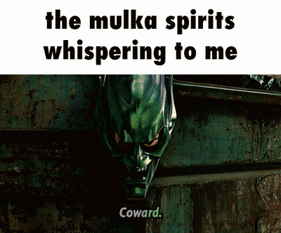 A Man In A Green Suit Is Standing In An Alleyway With The Words " The Mulka Spirits Whispering To Me " Above Him GIF