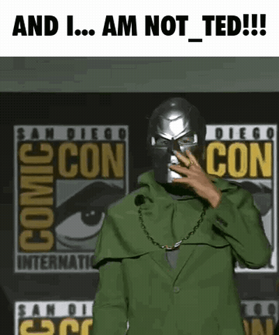 A Man In A Green Suit Is Standing In Front Of A Comic Con Sign . GIF
