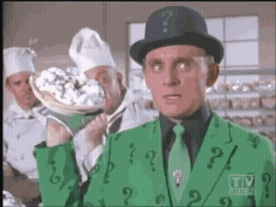 A Man In A Green Suit With A Question Mark On His Jacket GIF