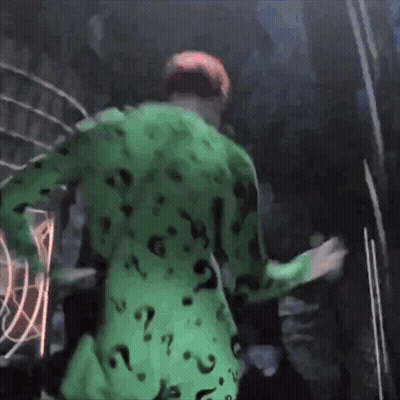 A Man In A Green Suit With Question Marks On It GIF