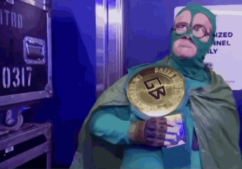 A Man In A Green Superhero Costume Is Holding A Gold Coin That Says Lb GIF