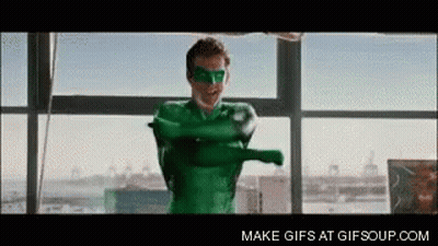 A Man In A Green Superhero Costume Is Standing In Front Of A Large Window . GIF