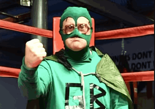 A Man In A Green Superhero Costume With The Letter B On The Front GIF